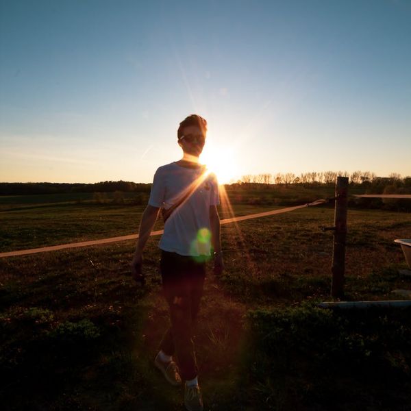 Silhouette of a man in a balanced pose against a golden sunrise.